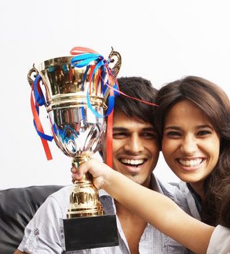 21399864 - kid raising a trophy with parents in background